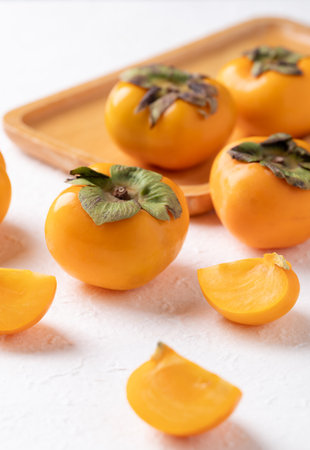 Sliced fresh ripe persimmon on white background, Autumn sweet fruitの写真素材