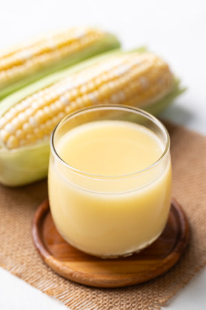 Sweetcorn milk in glass and fresh sweetcorn on white background, Alternative milk from plant, dairy freeの写真素材