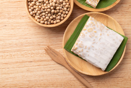 Top view of tempeh made from fermented soybeans on wooden background, Traditional Indonesian food, Healthy vegan and plant based ingredientsの写真素材