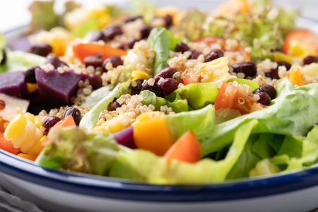 Healthy vegetable salad with lettuce, quinoa seed, azuki bean, corn, tomato, pumpkin and purple sweet potato in a bowl. Vegan and plant-based foodの写真素材
