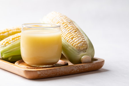 Sweetcorn milk in glass and fresh sweetcorn on white background, Alternative milk from plant, dairy freeの写真素材