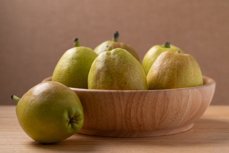 Fresh pears in a bowl on wooden backgroundの写真素材