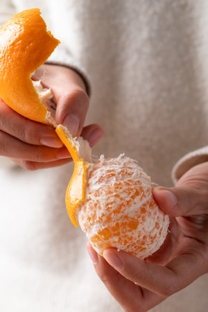 Mandarin orange fruit peeling by hand and eatingの写真素材