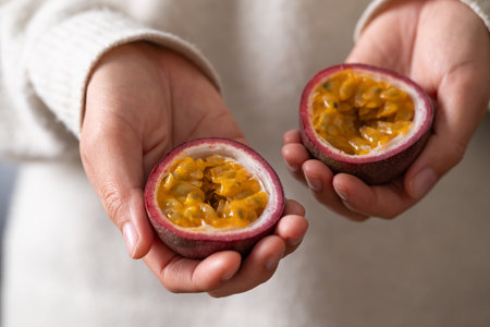 Fresh passion fruit holding by woman hand ready to eating, Tropical fruitの写真素材
