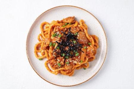 Stir fried Udon noodle with pork, spring onion, sesame seed and seaweed on topの写真素材
