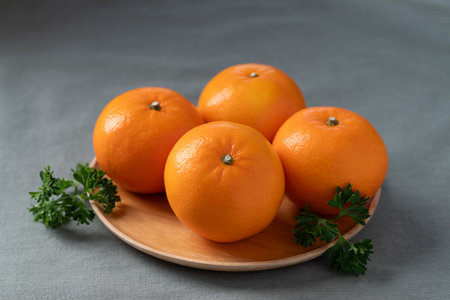Mandarin tangerine orange fruit on wooden plateの写真素材