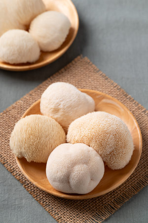 Fresh Lion's Mane mushroom,(Hericium erinaceus) on wooden plate, known for nootropic benefits and medicinal propertiesの写真素材