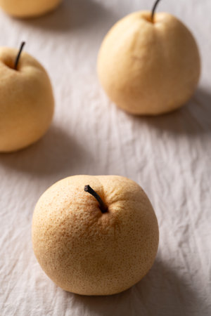 Fresh Asian pears on white wrinkled fabric with soft natural lightの写真素材