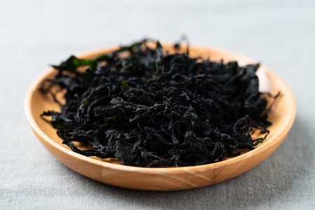 Dried wakame seaweed on a wooden plate, Healthy Asian food ingredientの写真素材