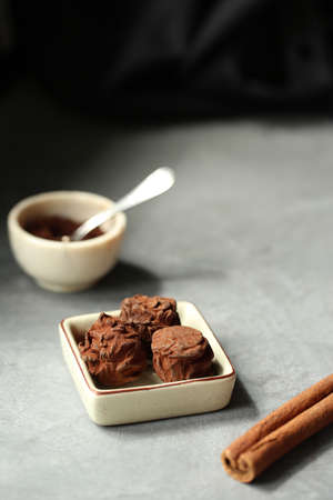 Chocolate truffle with a mint leaf, lilac flowers in the background. Eastern sweetness.