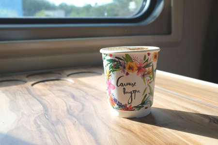 There is a paper cup on the train near the window and sunlight is falling.の写真素材