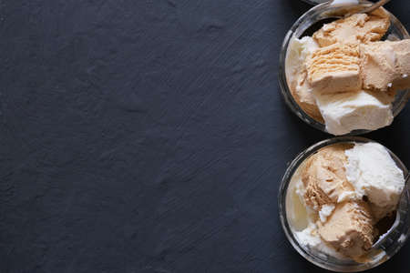 Ice cream in a glass bowl on a dark table. Place for your text.の写真素材