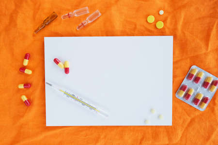 Creative layout of pills and capsules on orange white sheet background. Covid-19 or coronavirus concept. 3D rendering.の写真素材