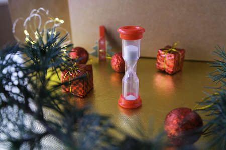 Hourglass and New Year's decor, place for text. Christmas countdown.