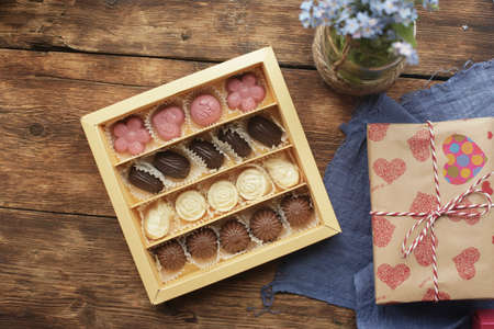 Candy of different shapes and heart on a wooden table, flat lay with space for text. Valentines day treat. High quality photoの写真素材