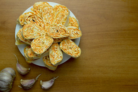 Vegetable pita roll with cheese, egg and carrots on a white plate. Quick holiday snacks.の写真素材
