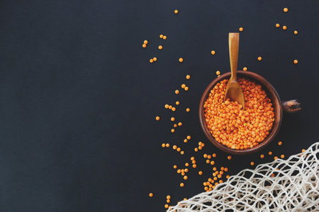 Top view of red lentils in a cup on a dark background. Vegan. Copy space.の写真素材