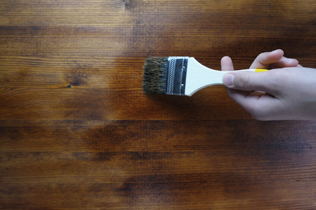 Flat paintbrush paints wood background. Preparing for the summer season. Home repairs.