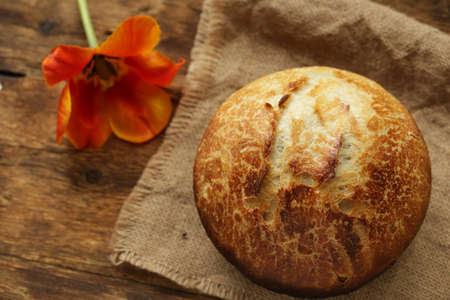 Freshly baked sourdough bread loaves on a dark wooden background. Top view with copy space.
