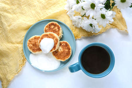 Delicious curd pancakes, Syrniki, served with sour cream. View from above. Russian, Ukrainian cuisine food.の写真素材