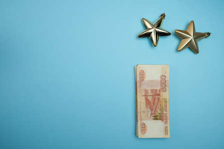Christmas background with the banknotes of the Russian Federation on a red background. Russian...