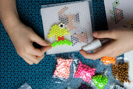 Step 2. The child plays with the mosaic at home. Children's creative game for early development and fine motor skills. Aquamosaicの写真素材