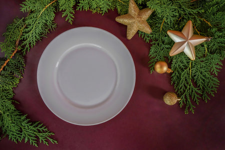 Empty white plate on a Christmas background. Flat lay, top view, copy space. Elegant Christmas table setting design. Christmas composition 2023の写真素材