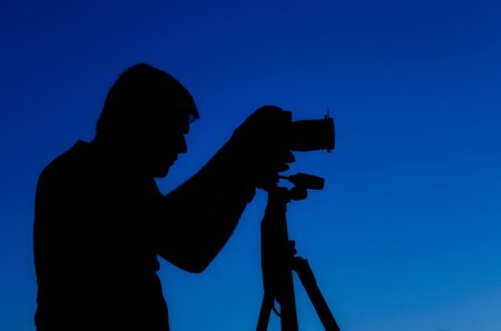 At the dusk a photographer adjust her cameraの写真素材