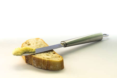 Knife on top of bread slice with butterの写真素材
