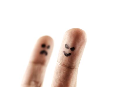 White background with two fingers representing sadness and happinessの写真素材