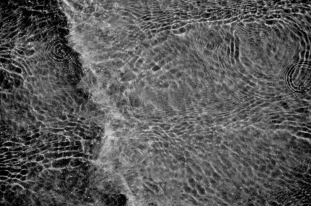 Night water ripple reflections. Black and White background. Dark tone.