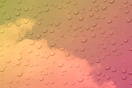 Waterdrop on the glass on blur pastel sky and clouds background.の写真素材