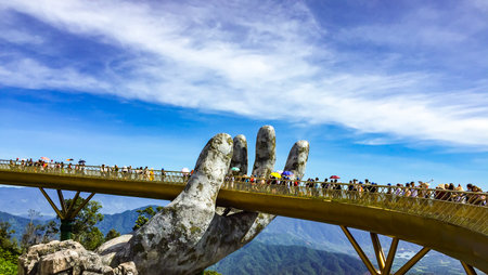 Danang,Vietnam -  Septemble 10, 2019 : The Golden Bridge is lifted by two giant.Tourists enjoy the excitement of walking on the golden bridge on holiday ,Ba Na Hill in Danang, Vietnam. Ba Na Hill mountain resort is a favorite destination for tourists.のeditorial素材