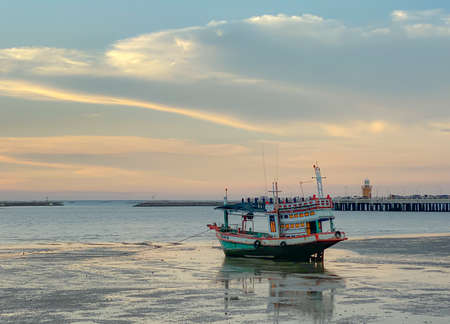 BANGSAEN,THAILAND 2022: Panorama of the evening atmosphere. Fishing boat stuck on the rocks on Ang...