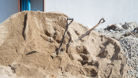 Garden shovel in the sand at the construction site of a new houseの写真素材