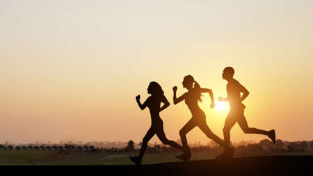 Silhouette of people jogging at sunset on bright nature background, healthy lifestyle, healthy rest, sport activities, summer vacation.の写真素材