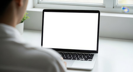 Mockup image of a woman working on laptop with blank white screenの素材