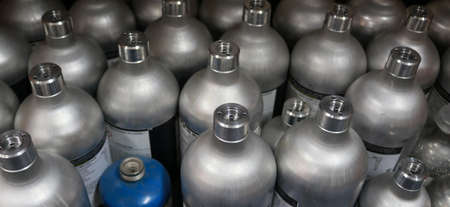 Close-up of a large group of small silver metal cylinders in a warehouse