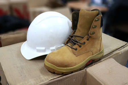 Safety boots and hardhat on the cardboard box. Safety concept.の写真素材