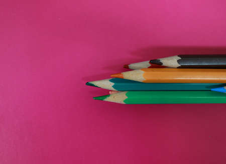 colored pencils on a pink background, close-up, copy spaceの写真素材