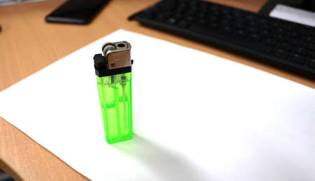 Green lighter on white paper with keyboard and mouse, closeup. Space for textの写真素材
