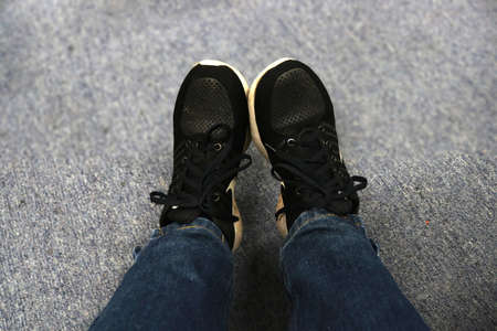 Selfie of a man wearing black sneakers and blue jeans standing on the floor