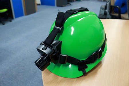 Green safety helmet on the table in the office. Safety concept.の写真素材