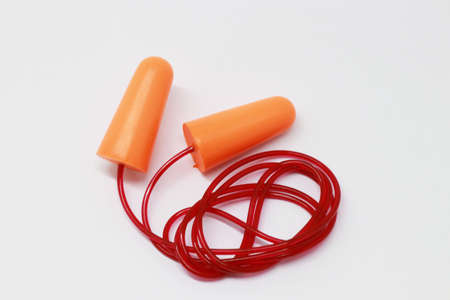 Orange earplugs on a white background.