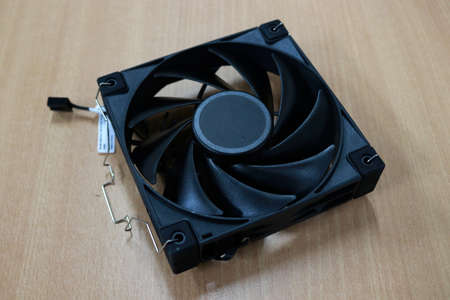 A closeup shot of a black computer fan on a wooden surfaceの写真素材