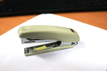 Stapler on a white sheet of paper. High quality photo