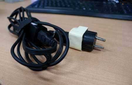 Electrical plug and cable on the desk in the office. Selective focus.の写真素材