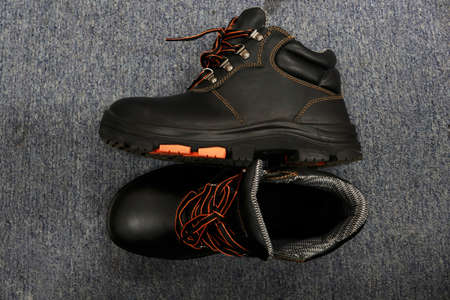 A pair of black men's boots on a gray background. High quality photo