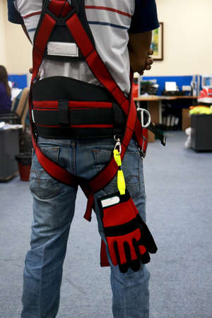 Rear view of an African-American man wearing a safety harness.の写真素材