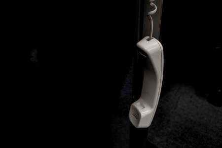 Close-up of a white telephone handset on a black background.の写真素材